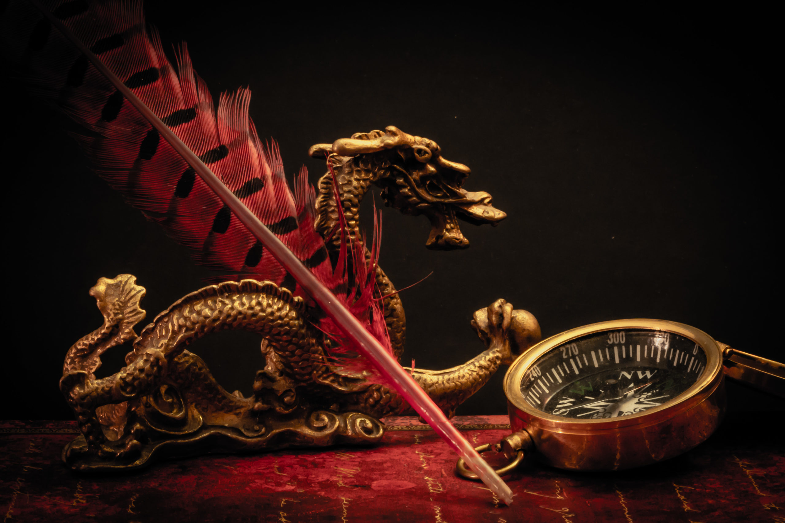 Dragon, plume, cahier et boussole